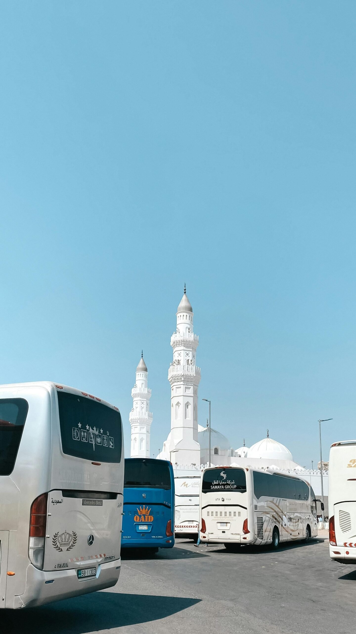 A sunny day with buses parked near the historic Quba Mosque in Medina, Saudi Arabia.