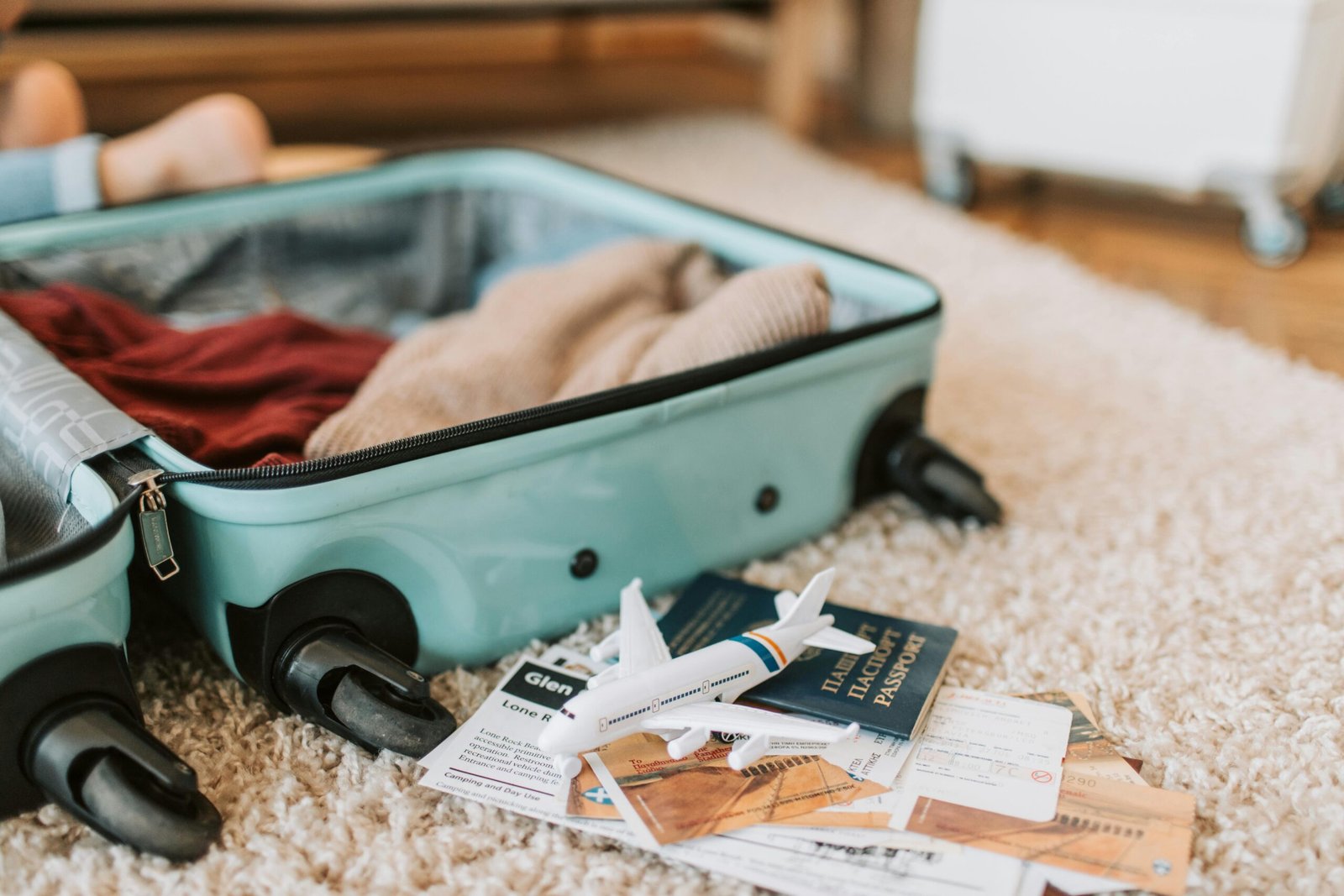 Close-up of an open suitcase with travel essentials like passport and tickets, ready for a journey.Mashaer Fleet