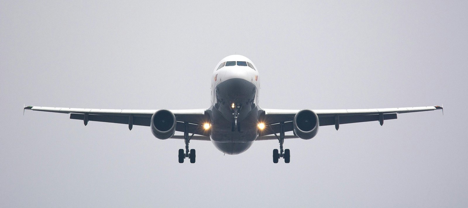 A commercial airliner captured head-on, preparing to land against a cloudy sky. mashaer fleet